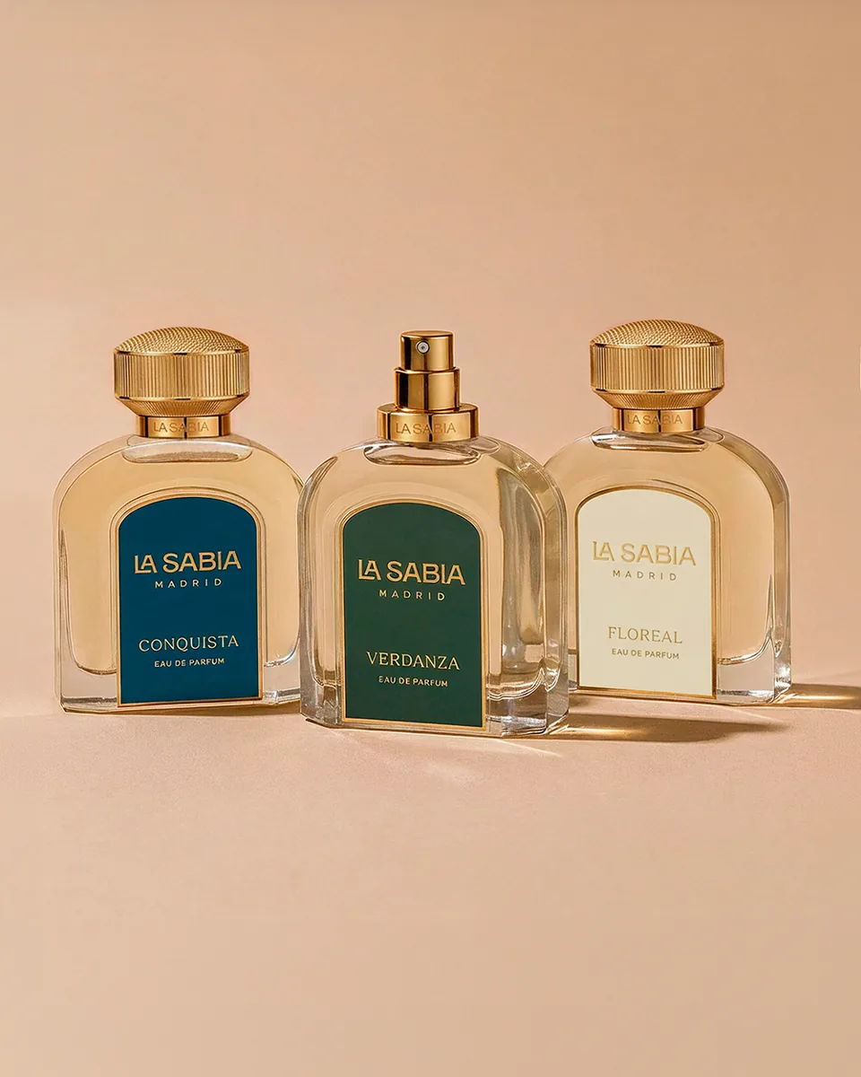 Three fragrance bottles with blue, green and cream labels on a peach backdrop · TimeLäB Studio
