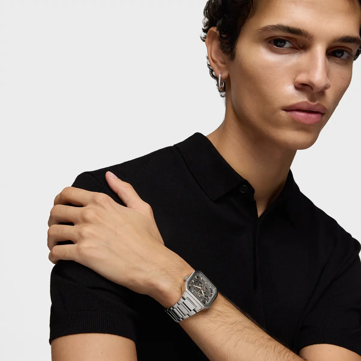 Model in a black polo wearing a steel watch · Fashion retouching, TimeLäB Studio Barcelona