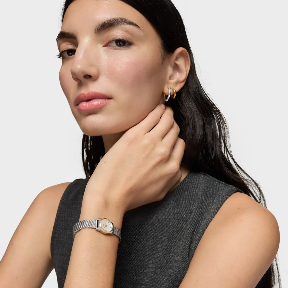 A model in grey with a gold watch, hand at the neck · Fashion retouching, TimeLäB Studio Barcelona