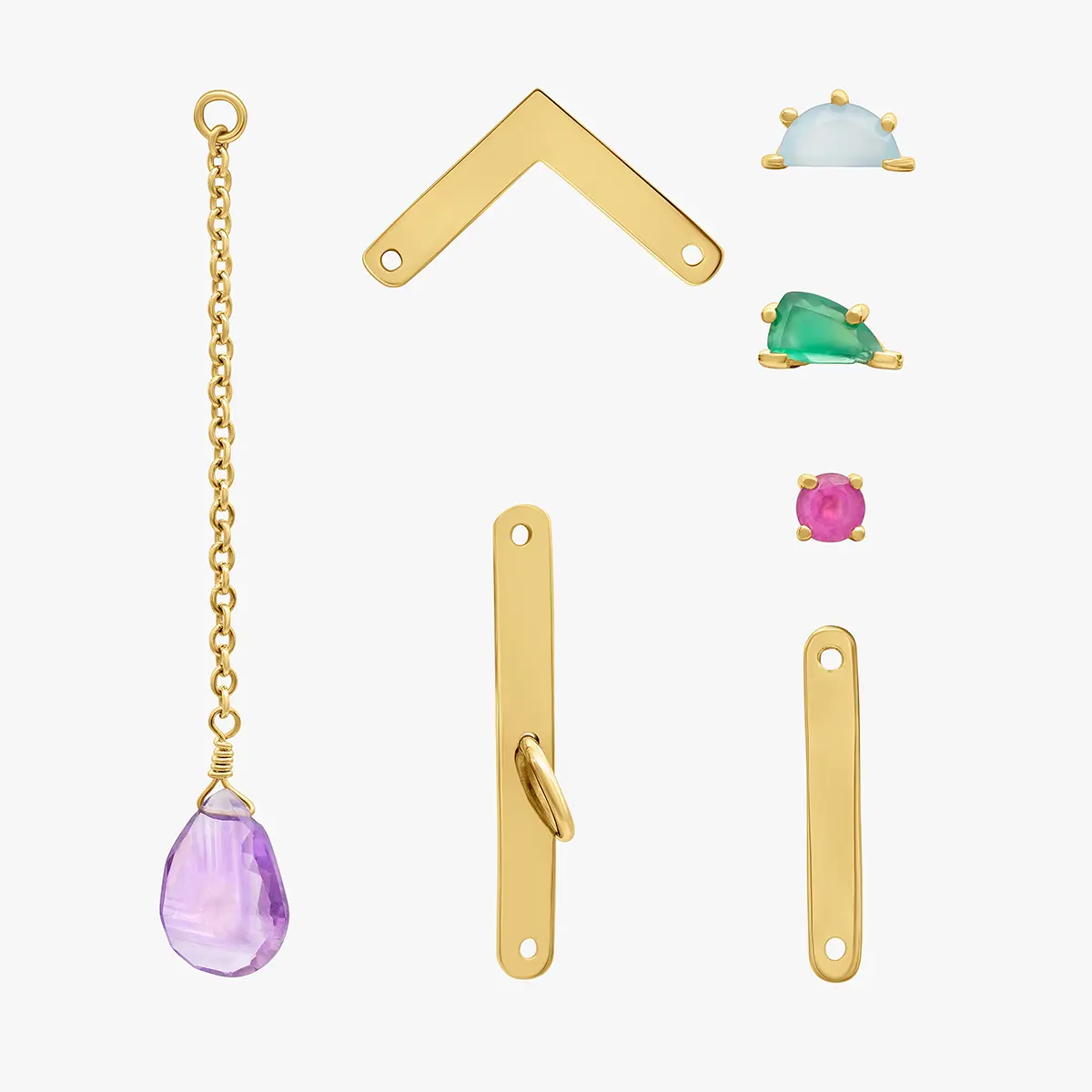 Flat lay of gold charms and a stone pendant · Jewellery photography, TimeLäB Studio Barcelona