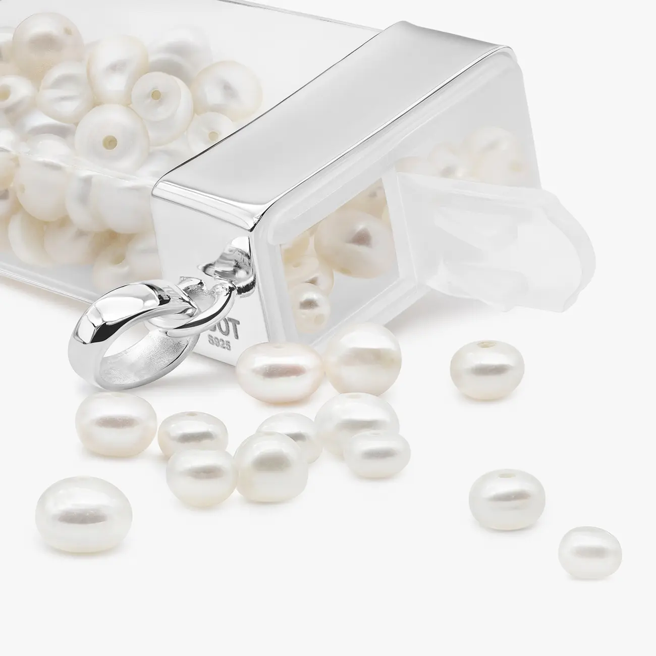 The pearl-filled Tous pendant open, with the pearls spilling out · Jewellery photography, TimeLäB Studio Barcelona
