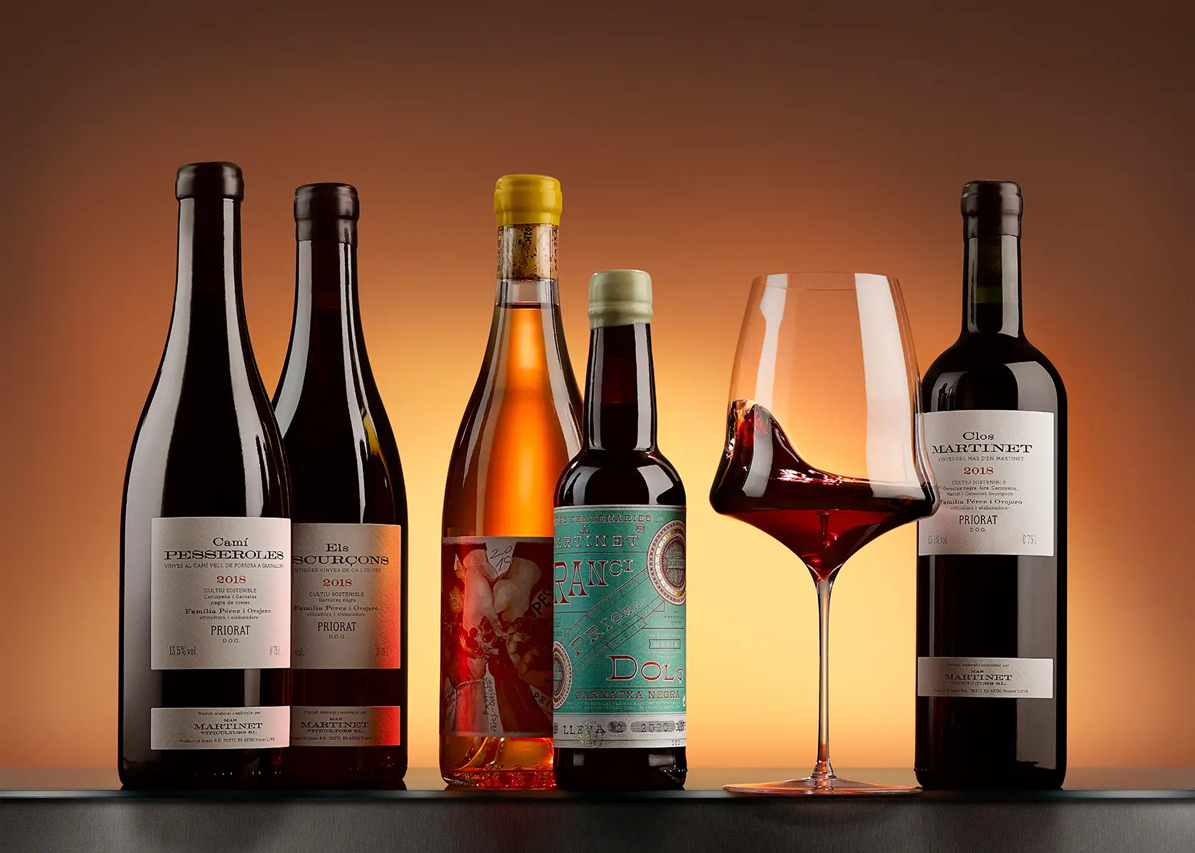Row of wine bottles lit against an amber background · Product photography, TimeLäB Studio Barcelona