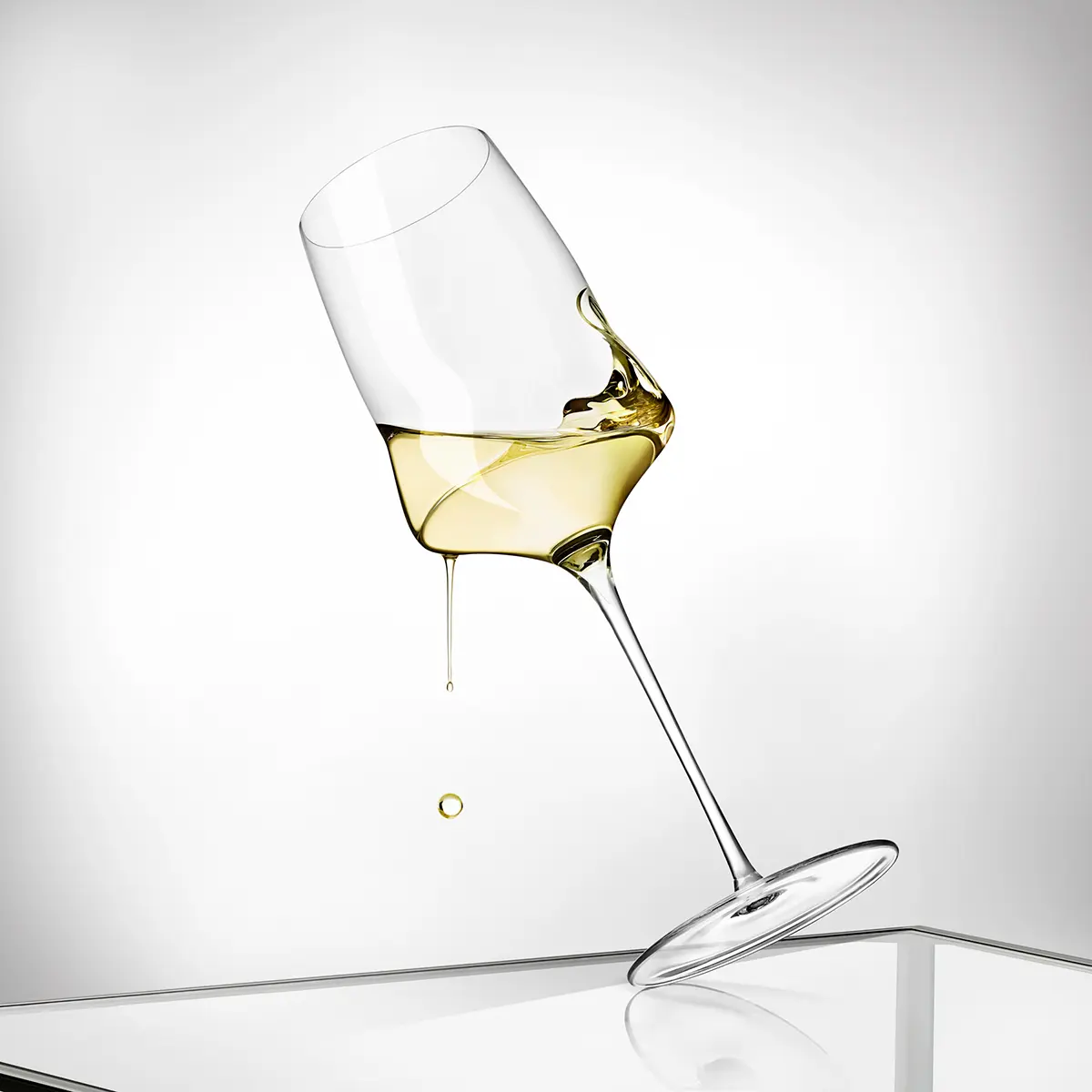 Tilted white wine glass with the wine held mid-pour · Product photography, TimeLäB Studio Barcelona
