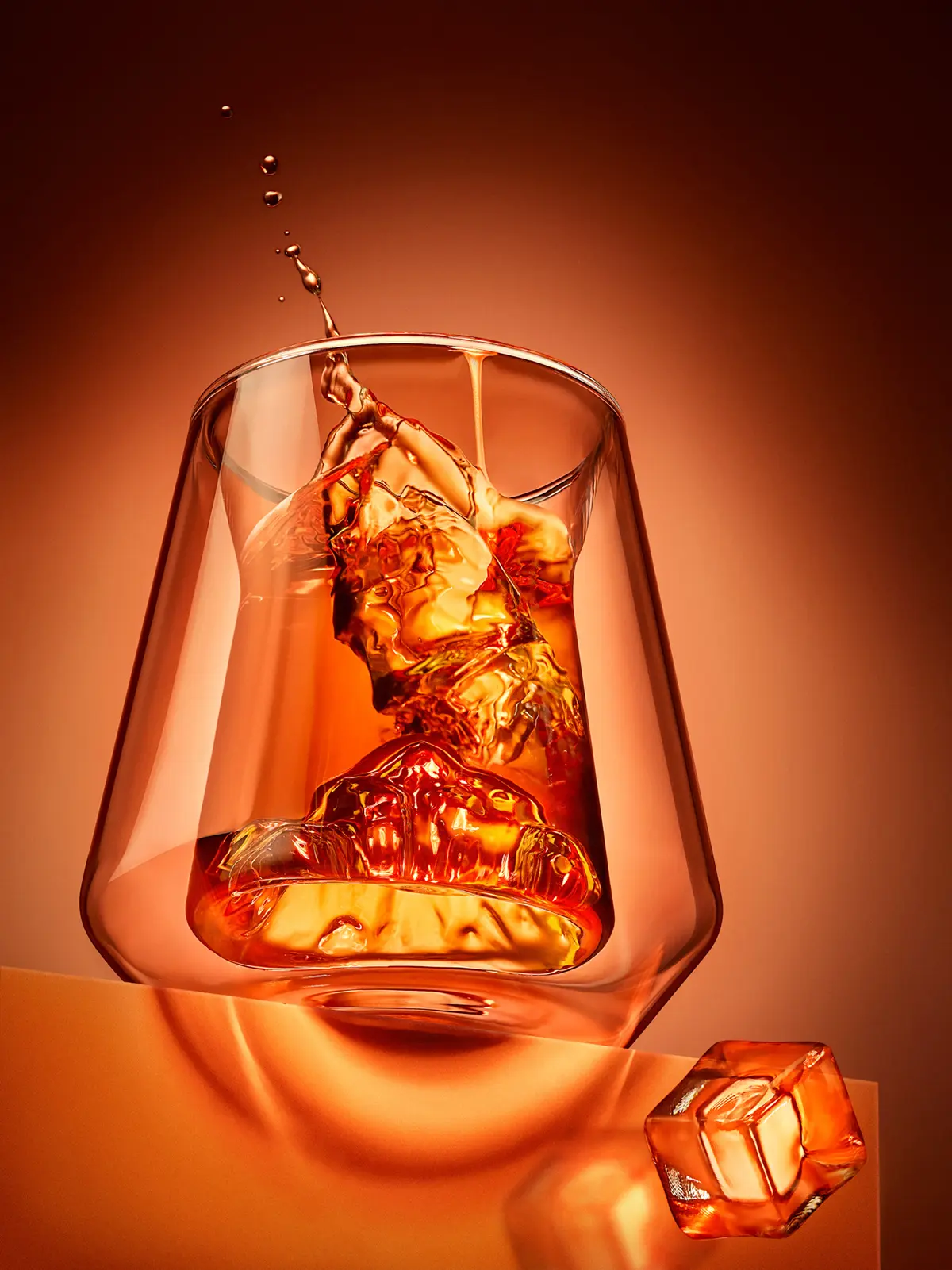Whisky tumbler with ice and a liquid splash frozen in the air · Product photography, TimeLäB Studio Barcelona