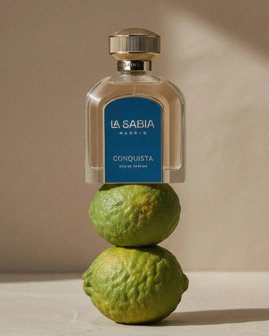 A bottle balanced on two stacked limes · TimeLäB Studio