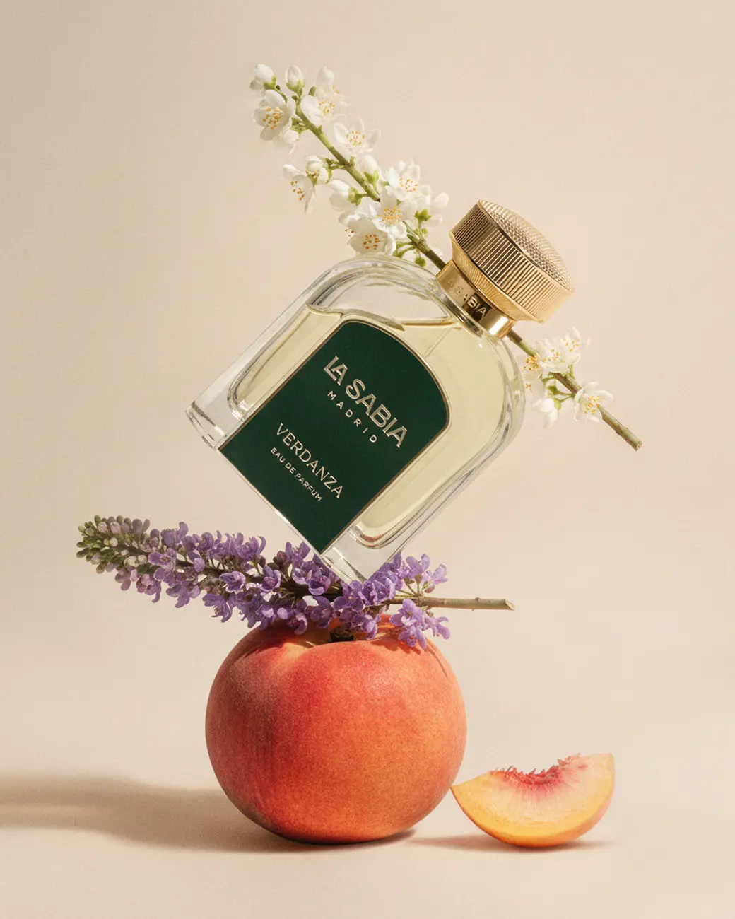 A bottle tilted over a peach, with lavender · TimeLäB Studio