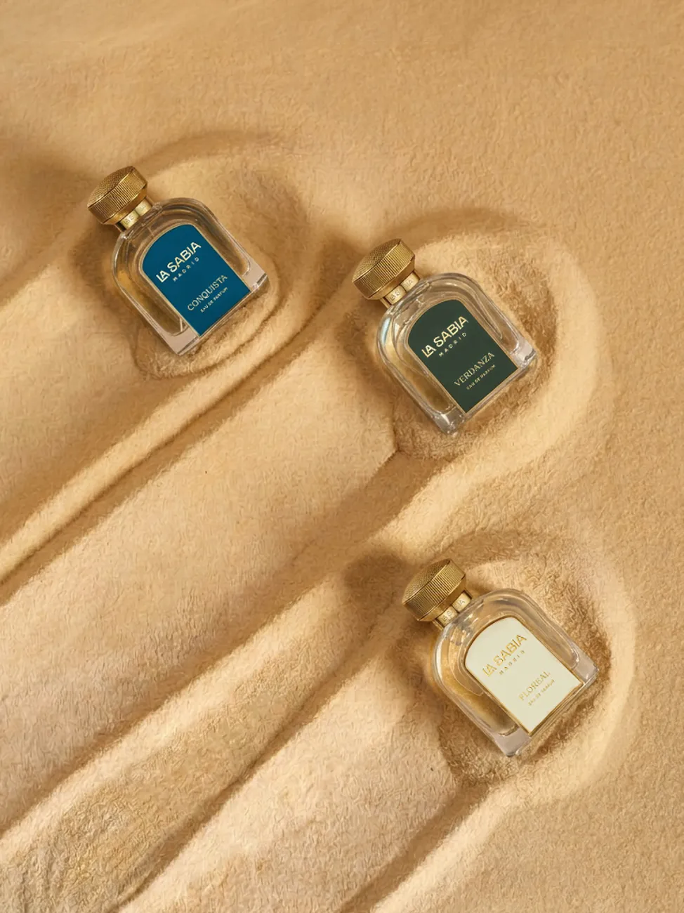 Fragrance bottles nestled in beach sand · TimeLäB Studio