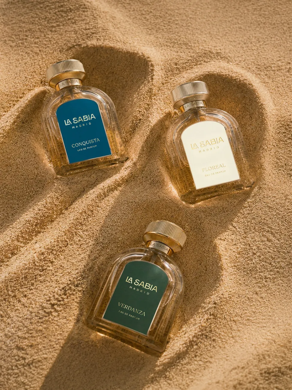 Fragrance bottles arranged in warm sand · TimeLäB Studio