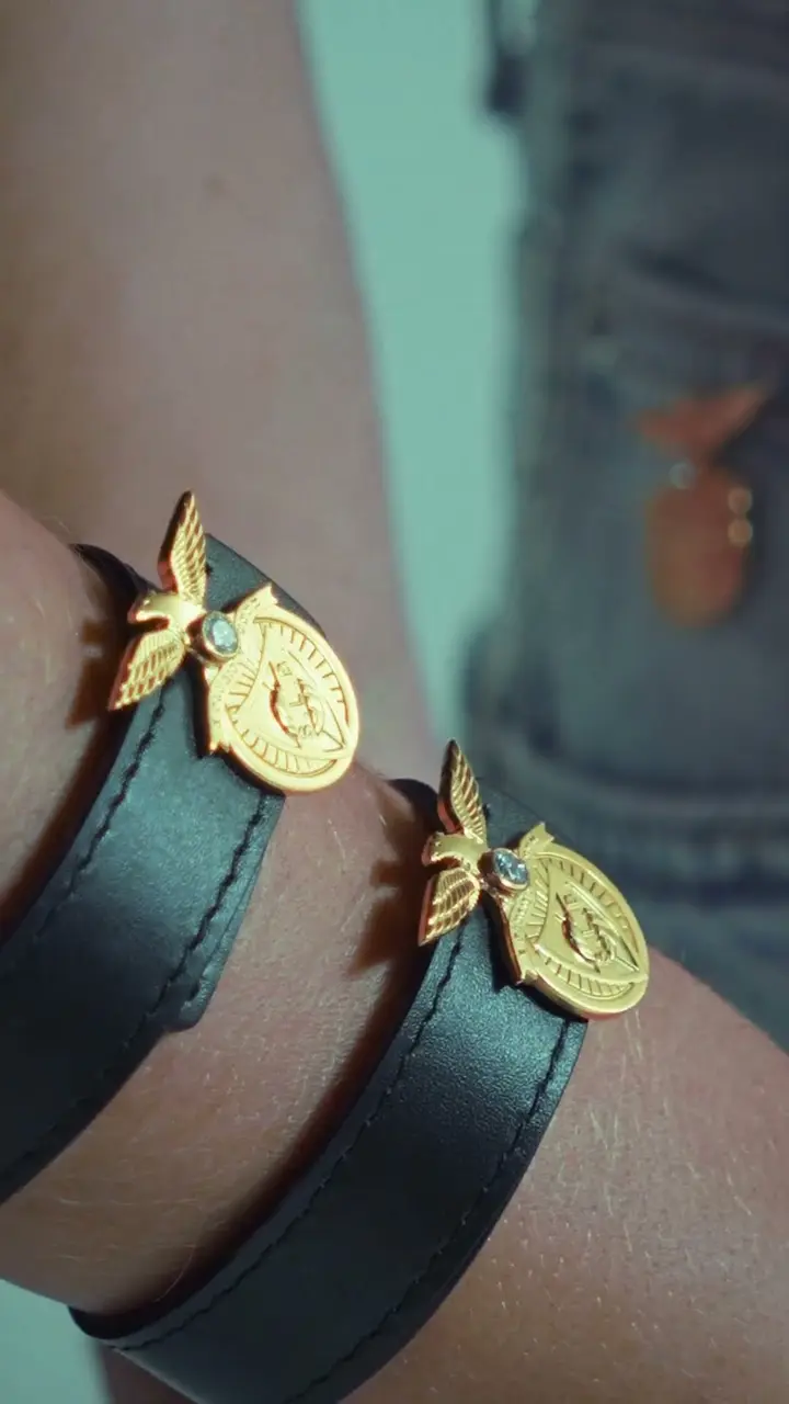 Gold charms on a woven bracelet
