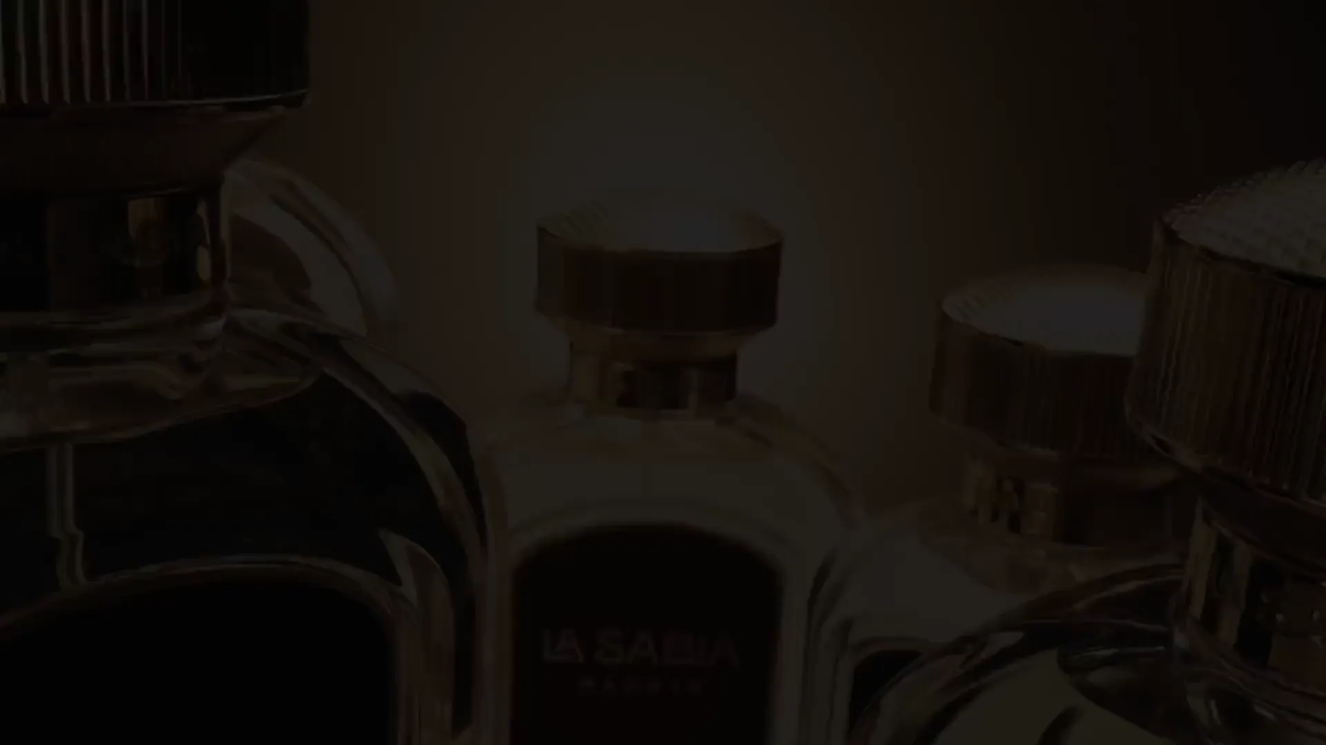 Close-up of luxury fragrance bottle caps in warm cinematic light — a TimeLäB Studio film